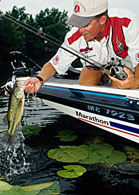 Art Ferguson III lips a largemouth caught under some lily pads.