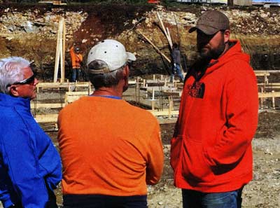 Greg Graves (middle), worked with his engineer and construction crew almost daily His presence made a difference. Here, they are discussing the foundation for the boat house. 