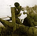 Young Edwin Morgan holds daughter Mary in his wooden boat on Richmond Mill Lake.