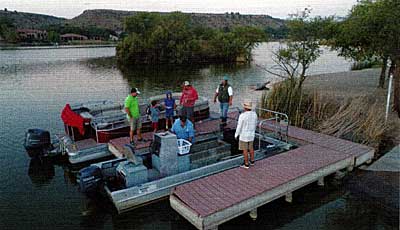 Big day in the making — In blue, biologist Bob Lusk — the Pond Boss — makes ready to launch an electro-shocking boat at Ransom Canyon Lake in West Texas, (photo by Ron McWilliams, <BlazingGloryProductions.com>)